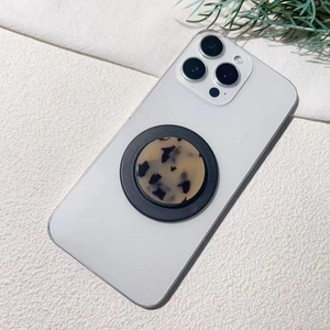Dettaglio del supporto per telefono tartarugato su un iPhone bianco su base in pietra