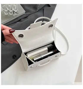 Detail view of the white hourglass bag interior showing magnetic closure and storage capacity