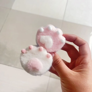 Close-up of pink and white plush cat paw phone grip with soft faux fur texture