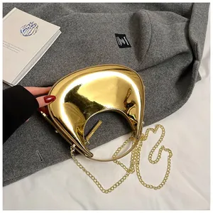 Detailed close-up of gold mirror finish crescent bag with elegant metal chain strap