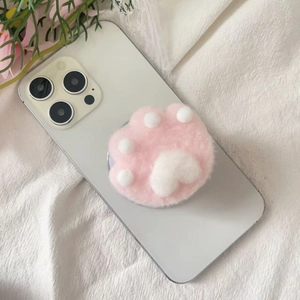 Close-up of cute pink and white plush cat paw phone grip on a white smartphone