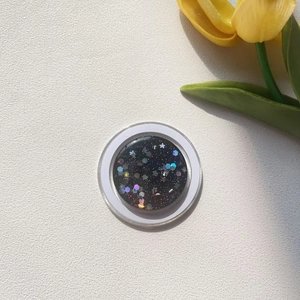 Macro view of circular magnetic phone holder with black starry glitter and sequins