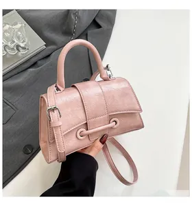 Detail of pink pleated hourglass handbag with silver hardware and adjustable strap