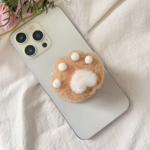 Close-up of cute plush cat paw phone socket on white smartphone with soft floral background