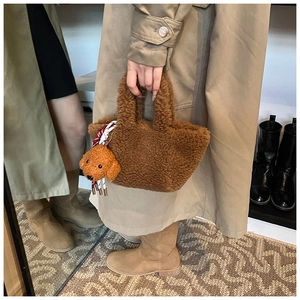 Detail of plush brown teddy tote bag with matching poodle charm and textured faux fur finish