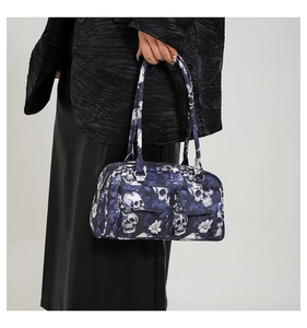 Detail of gothic floral skull pattern on canvas shoulder bag with dual front pockets