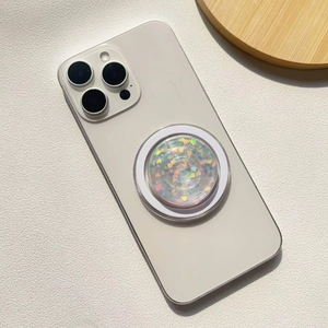 Macro detail of round magnetic phone holder with iridescent heart sequins on white smartphone
