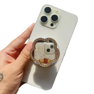 Luxurious flower-shaped rhinestone phone grip mirror on a white smartphone