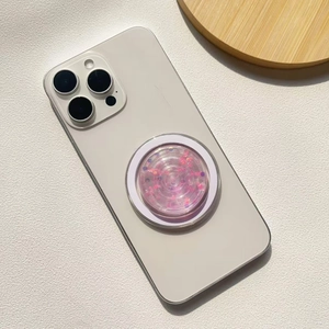 Close-up of pink glitter pop-up phone socket mounted on a white smartphone back