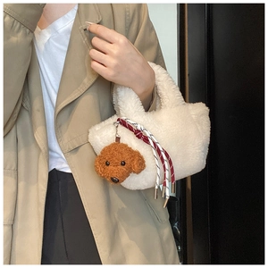 Detail of white plush bucket bag with brown teddy dog charm and woven rope decoration