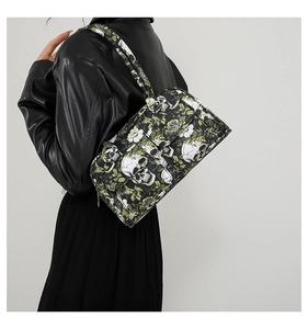 Shoulder bag detail with skull and floral print on a model wearing black leather jacket