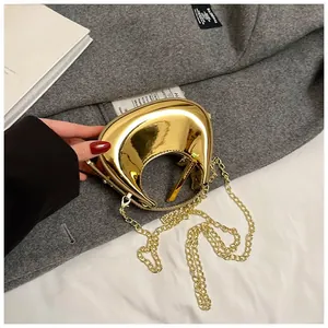 Detail of a crescent-shaped gold metallic mirror handbag with detachable chain strap