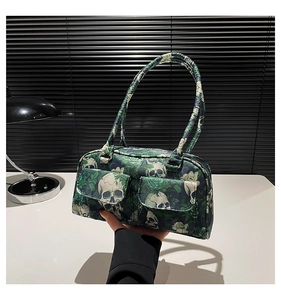 Detail of dark green bag with skull and rose print and two front utility pockets
