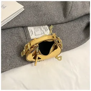 Detail of the golden mirror-finish mini crescent bag with metal chain strap