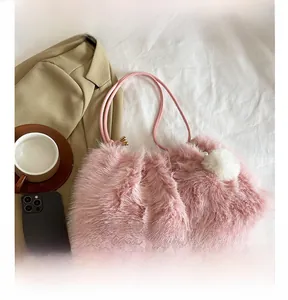Detail of pink faux fur handbag with a soft pom-pom charm and slim shoulder strap
