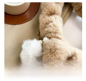 Detailed view of the plush dumpling bag with golden metal chain and white pearl accents