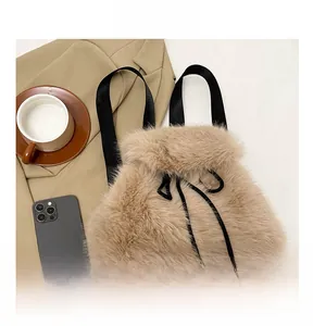 Detail view of the beige plush drawstring bucket bag with black straps and soft texture