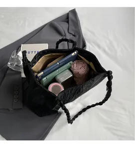 Macro view of a large black tote bag showing spacious interior with tablet and accessories