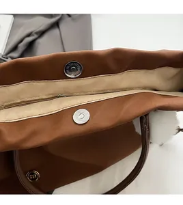 Detail view of large tote bag with silver magnetic snap and interior zipper pocket