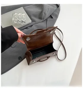 Detail view of brown vintage texture leather bag with magnetic buckle closure