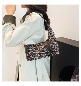 Detail of leopard print bucket bag featuring smooth leather shoulder strap and silver zipper