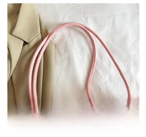 Detail of pink faux fur shoulder bag with slender straps and gold hardware accents
