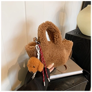 Detailed texture of brown plush bucket bag with a cute teddy dog charm and woven strap