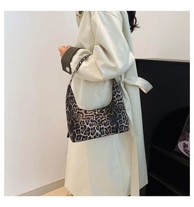 Close-up of leopard print hobo bag texture and stitching on a neutral background