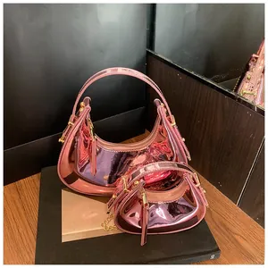 Detail of pink metallic crescent bags in two sizes with gold chains on a display stand