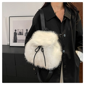 Detail of white faux fur backpack featuring black drawstring closure and soft plush texture