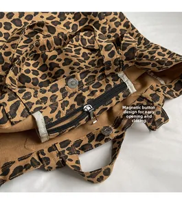 Detail of leopard print canvas tote featuring metal magnetic snap and zipper closure