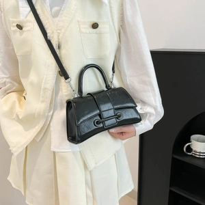Fashionable black hourglass handbag with glossy cracked leather texture and crossbody strap