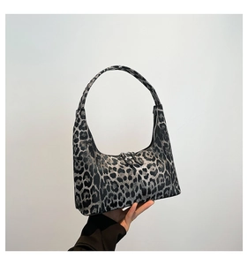 Detailed close-up of a leopard print bucket bag with metal zipper and single handle strap