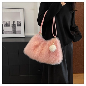 Detailed shot of pink plush shoulder bag with woven handle and pearl charm detail