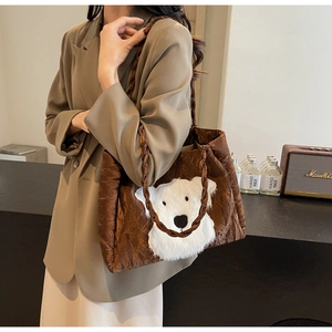 Detail of vintage brown tote bag featuring a white plush polar bear patch and woven handles