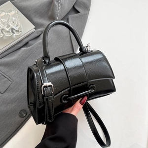 Chic black hourglass handbag in glossy wrinkled leather with adjustable shoulder strap