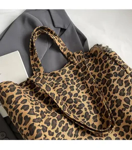Detail of leopard print canvas tote bag featuring wide shoulder straps and large capacity