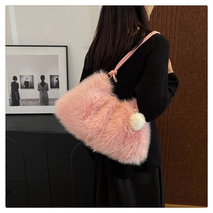 Pink faux fur shoulder bag with soft plush texture and fuzzy pom-pom charm detail