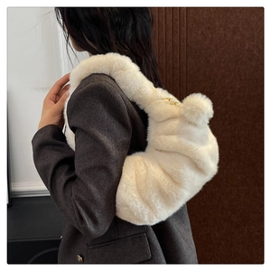 Detail of plush off-white dumpling bag featuring pearl chain and soft fur texture