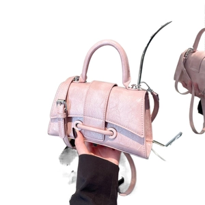 Chic pink hourglass handbag with textured faux leather and adjustable crossbody strap