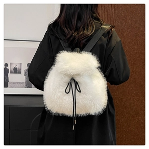 Detail of white plush backpack with drawstring closure and contrasting black straps