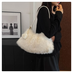 Detail of plush off-white faux fur shoulder bag with soft texture and pearl gold pendant