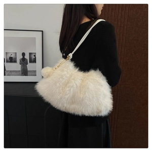Detail view of a cream faux fur shoulder bag with soft plush texture and gold hardware