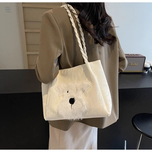 Detailed shot of white tote bag featuring a plush schnauzer motif and braided straps
