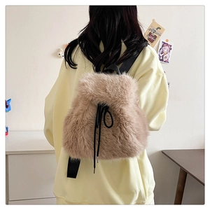 Close-up of a light brown plush backpack with drawstring closure and fluffy rabbit fur texture