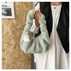 Detail of light green plush dumpling bag with pearl pompom charm and gold chain