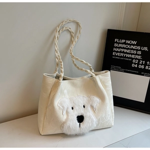 Detail of off-white tote bag with plush dog applique and woven braided handle