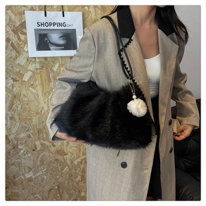Macro detail of black faux fur shoulder bag with leather strap and pearl charm accent