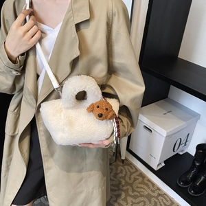 White teddy fleece bucket bag with cute brown puppy charm worn with beige trench coat