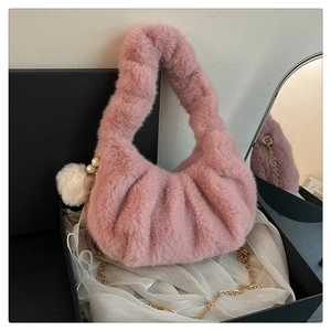 Detailed close-up of pink faux fur dumpling bag with gold chain and pearl charm